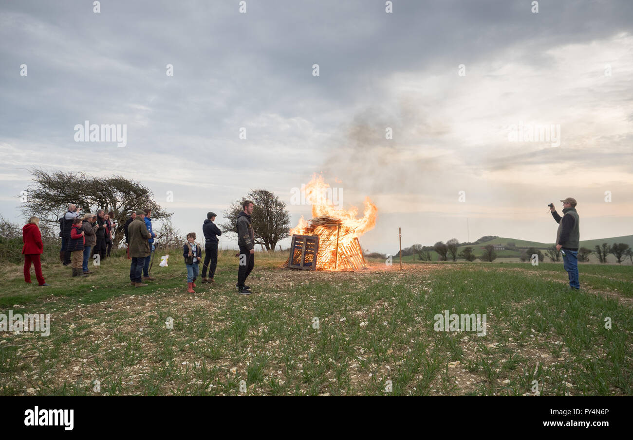a man taking a photo picture of spectators watching a lit fire beacon for queen's 90th birthday in Whitwell, Isle of Wight, UK Stock Photo
