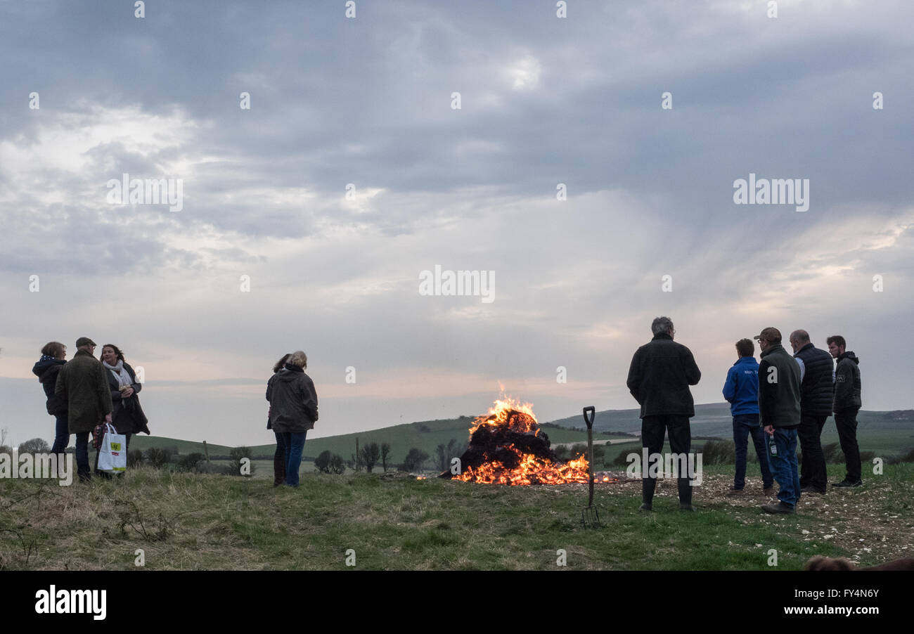 a group of spectators standing around watching a lit fire beacon for queen's 90th birthday in Whitwell, Isle of Wight, UK Stock Photo