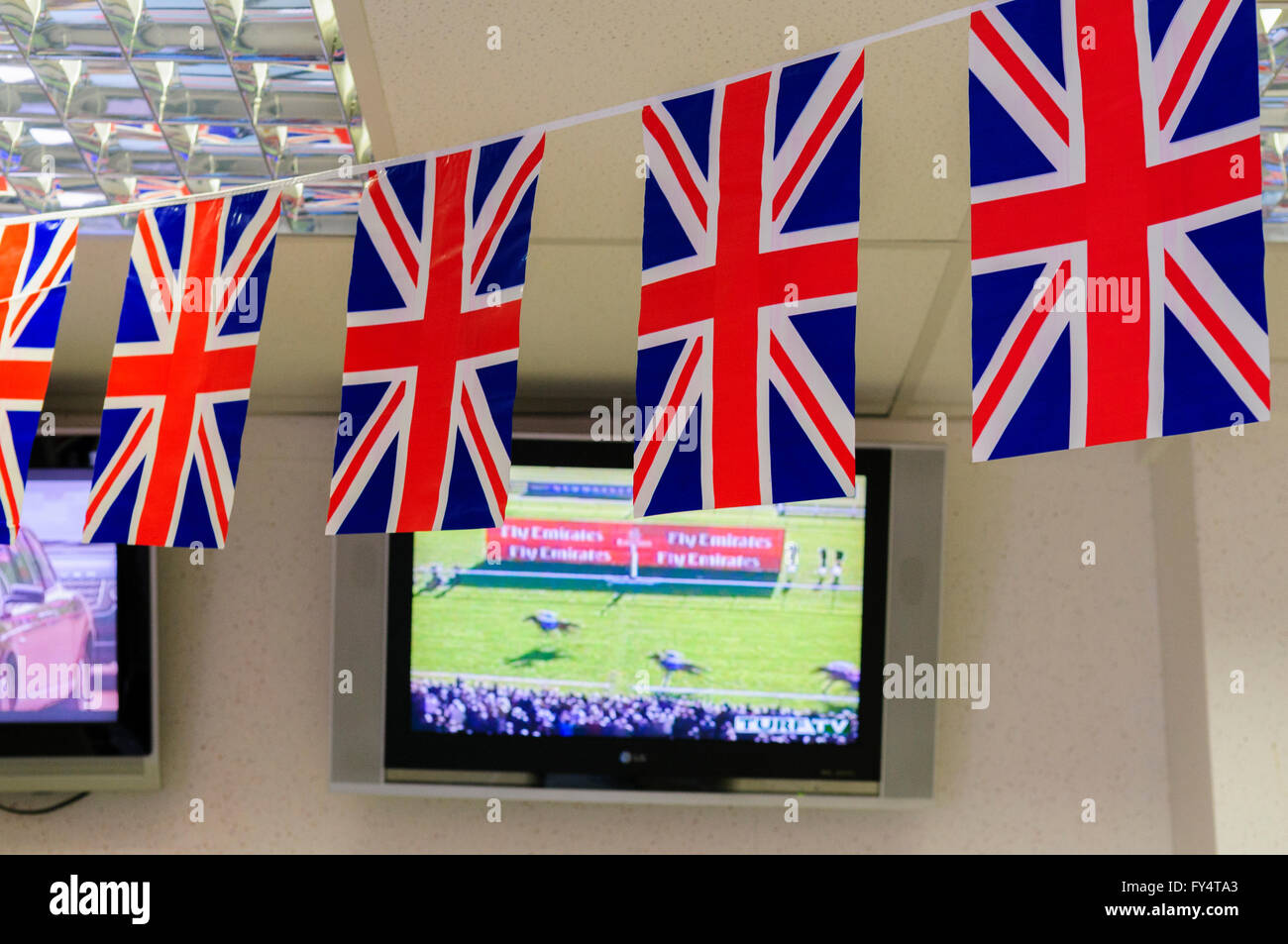 Inside a Bookmakers with Union Flag bunting in front of the TV television screens and monitors Stock Photo