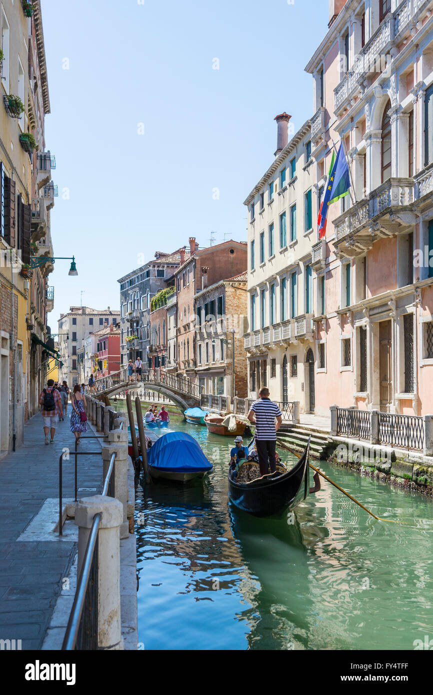 Venice,Italy-August 12,2014:Venetian gondoliers carry around some tourists  on a gondola in Venice During a sunny day inside her Stock Photo
