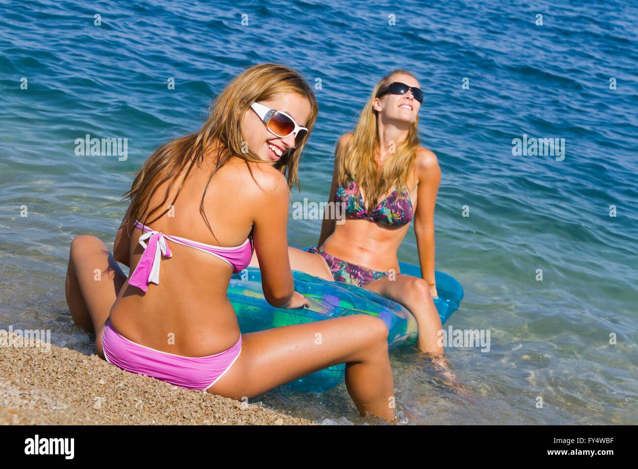 Two attractive girlfriends are having fun on beach friendship friend