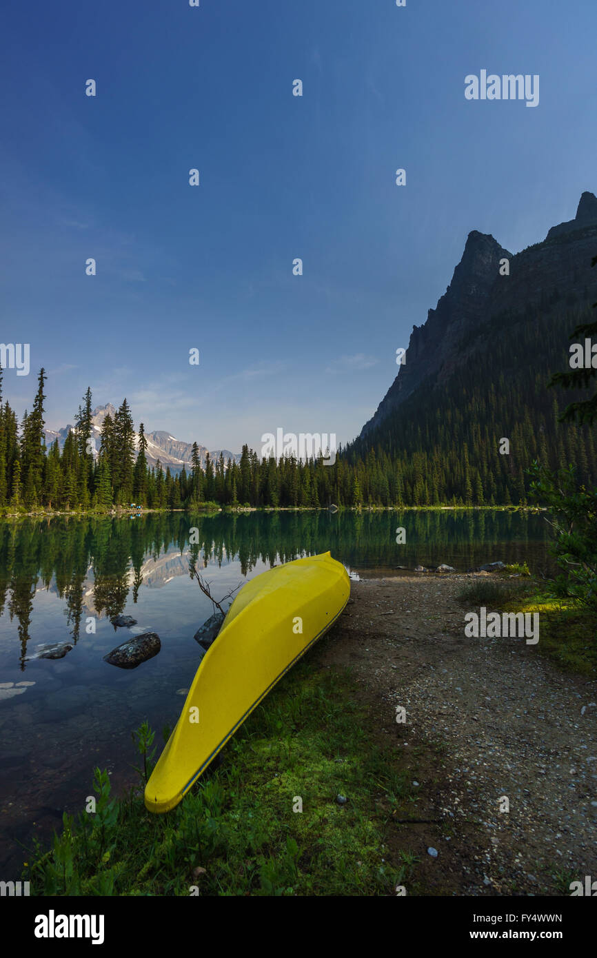 Yellow canoe resting ashore Lake O'Hara in Yoho National Park Stock