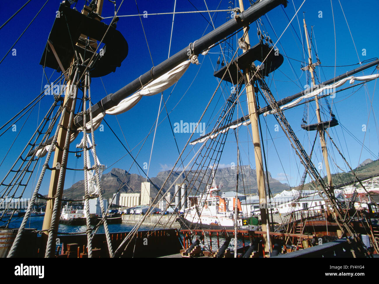 View of Cape Town and harbor through masts & rigging of historic sailing ship; Table Mountain; Cape Peninsula; South Africa Stock Photo