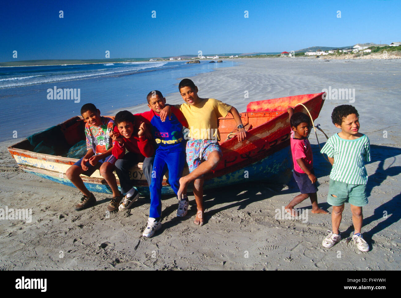 Children pose for a photograph on wooden fishing boat on beach; Cape Town; Cape Peninsula; South Africa Stock Photo