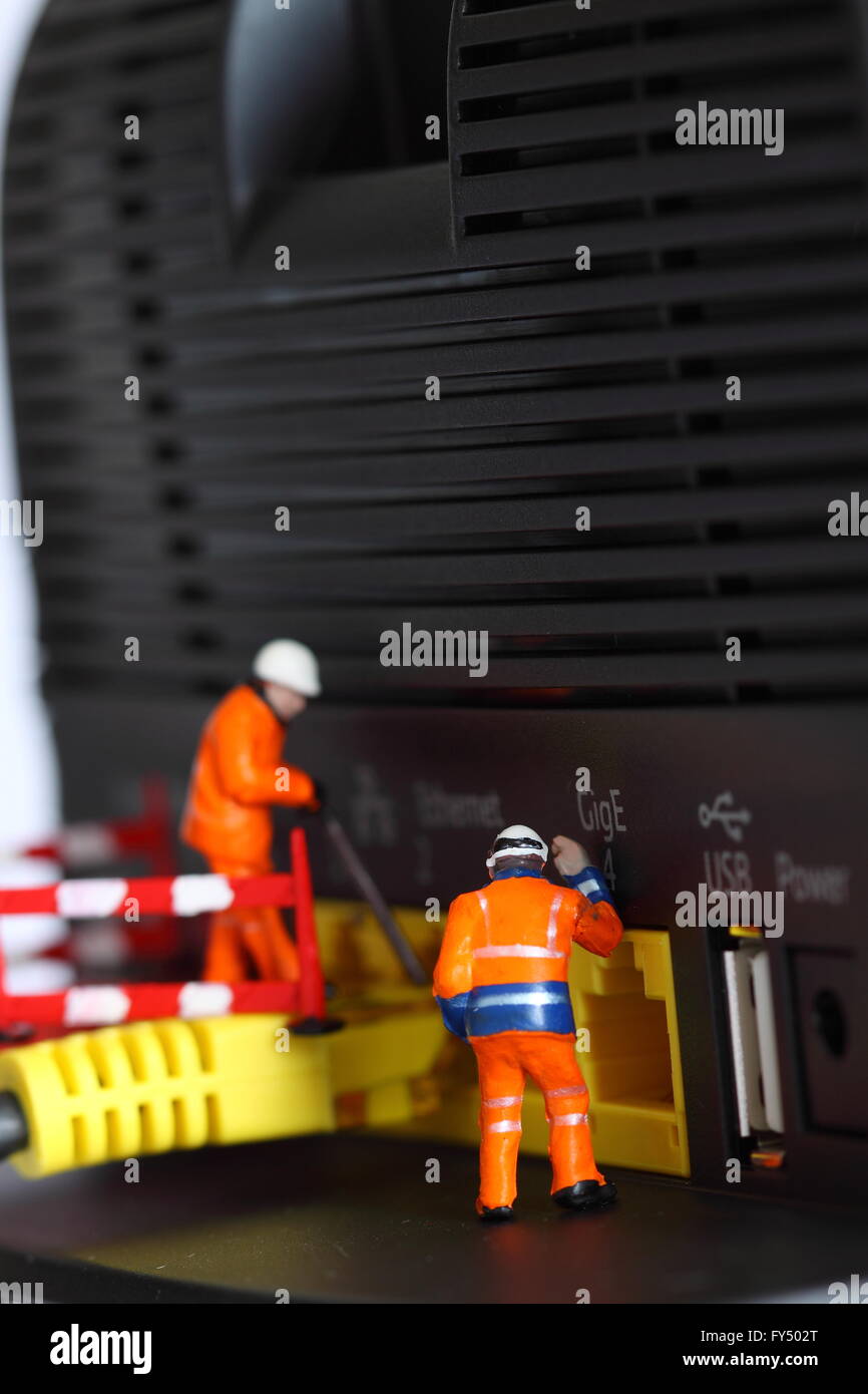 Miniature construction workers router connecting cable Stock Photo