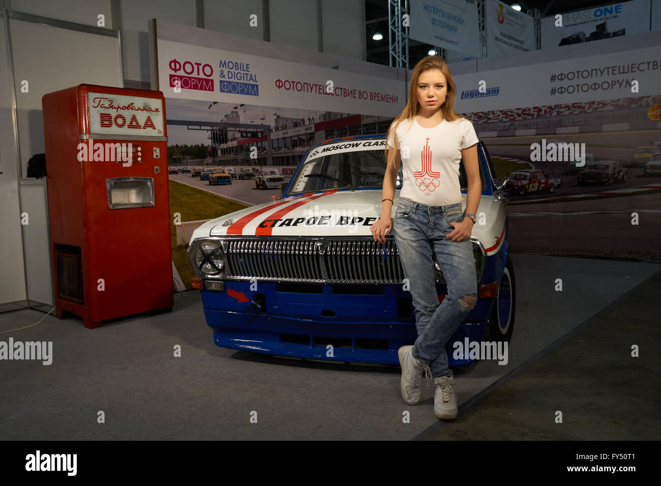 Moscow Crocus Expo, Moscow, Russia - April 15, 2016: Girl stands near old car at Photoforum 2016 Stock Photo