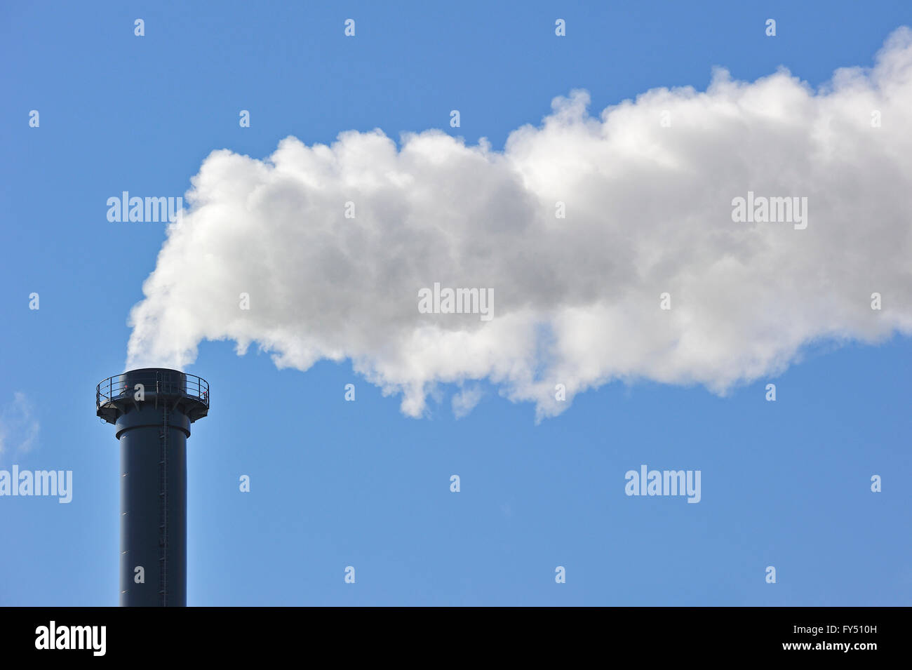 Conceptual image showing air pollution from industry showing chimney issuing fume into the atmosphere Stock Photo