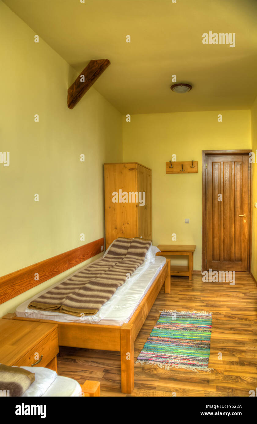 Clean hostel room with bed and wardrobe Stock Photo