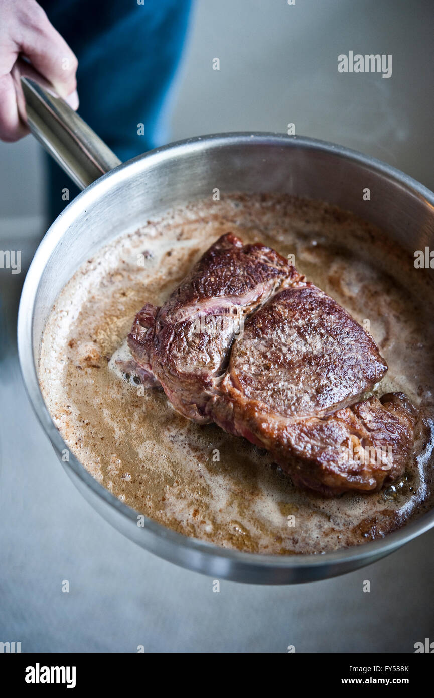 Grass-fed Angus Ribeye Steak in pan Stock Photo
