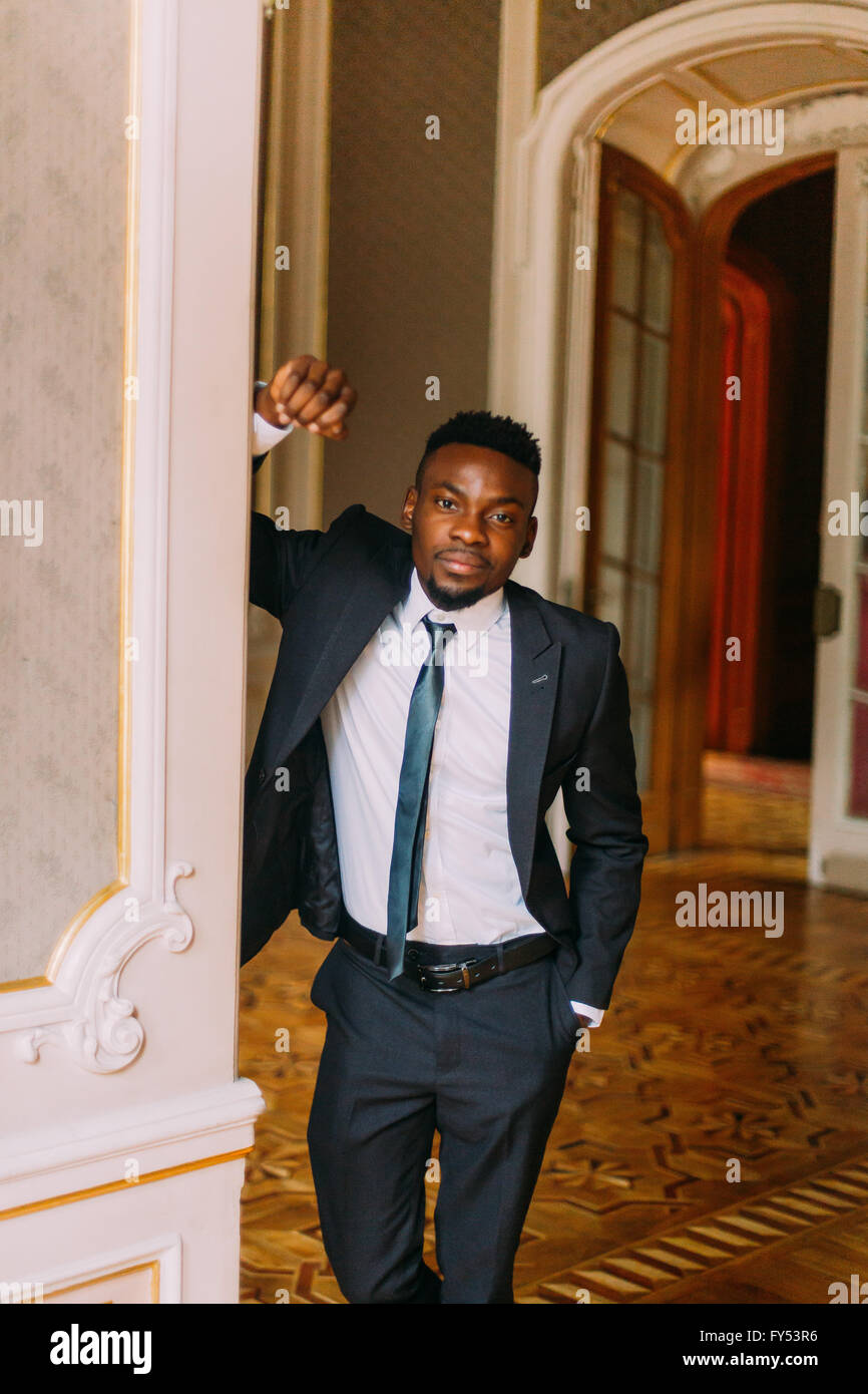 Handsome Groom In Black Suit Posing Luxurious Hotel Room