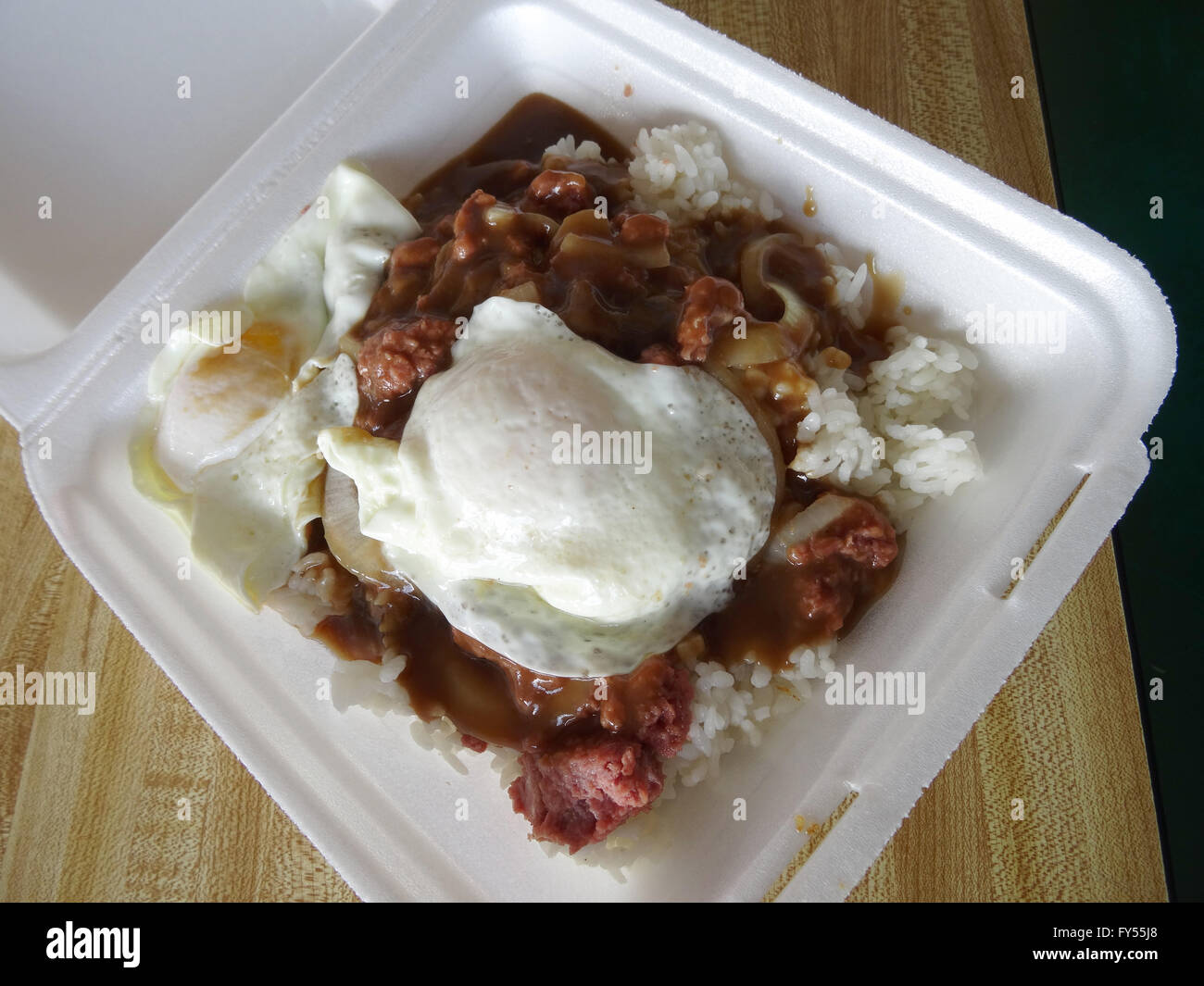 Braddha Moco featuring corn beef hash on top of rice covered in gravy with two eggs over easy on