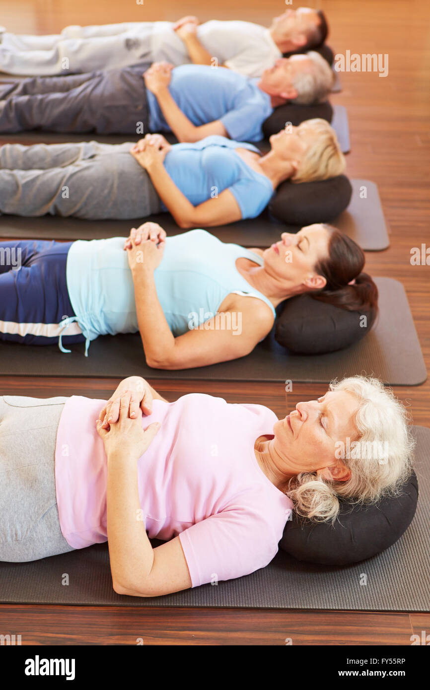 Group of seniors doing relaxation exercise in gym Stock Photo