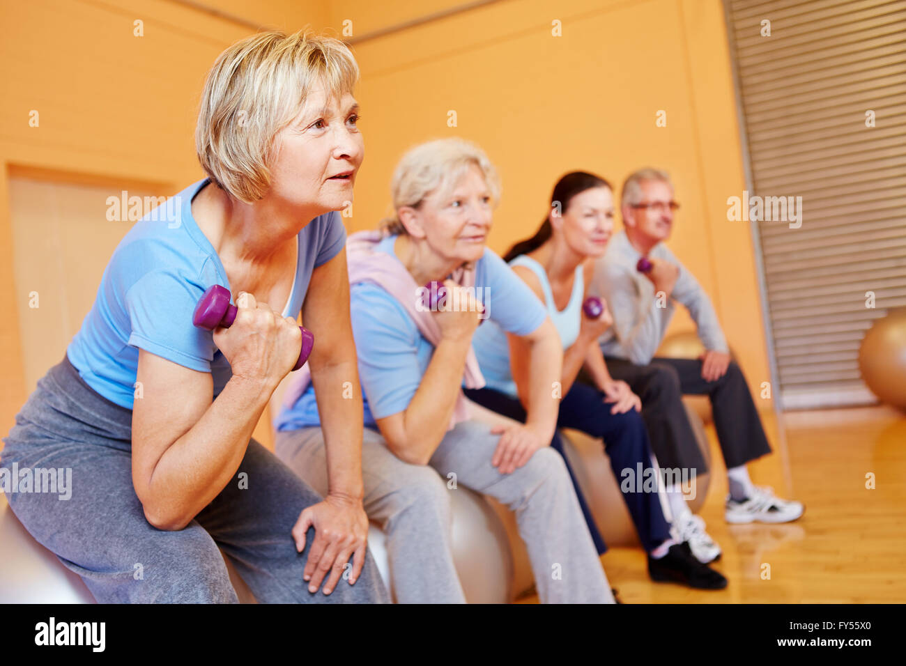 Group of senior people doing back training exercises in a gym Stock Photo