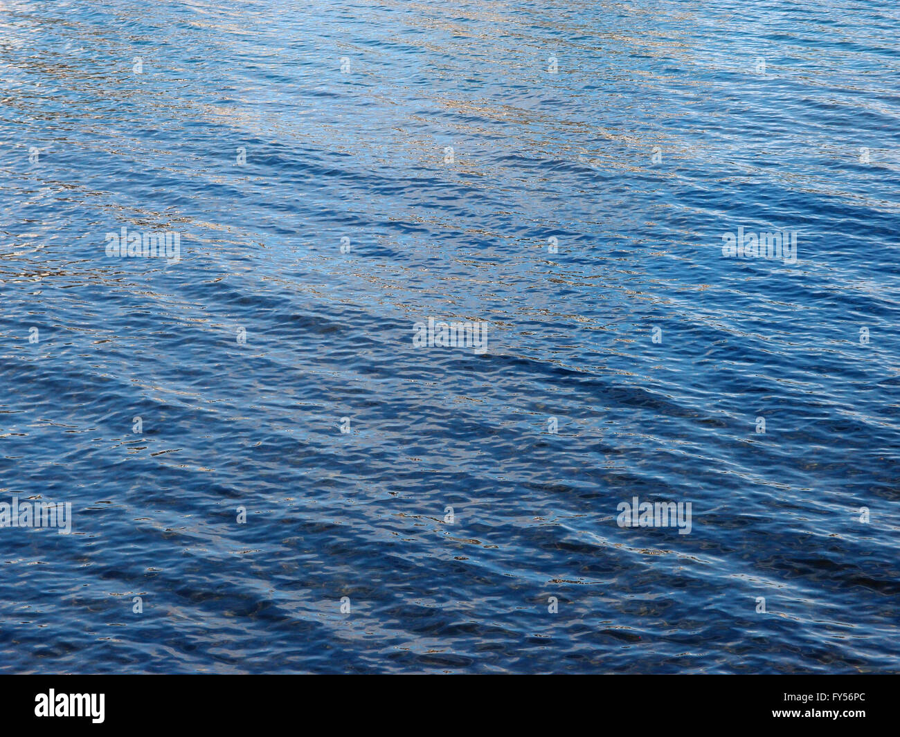 Ocean Water ripples off the coast of Oahu reflecting light.  Good for backgrounds textures. Stock Photo