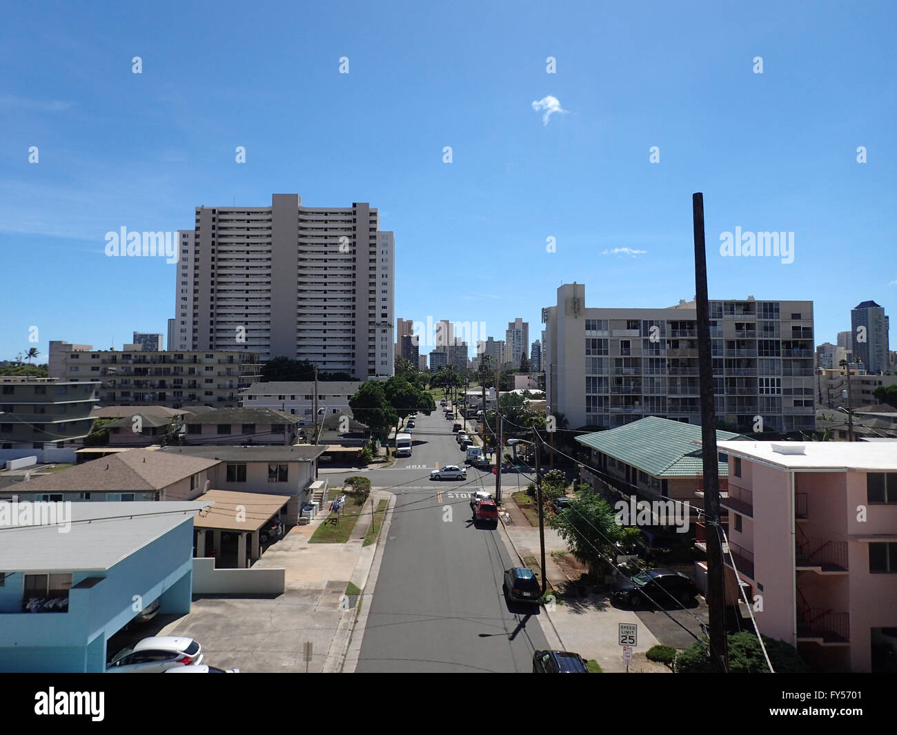 Kapahulu town scape featuring street with parked cars, homes, and condo