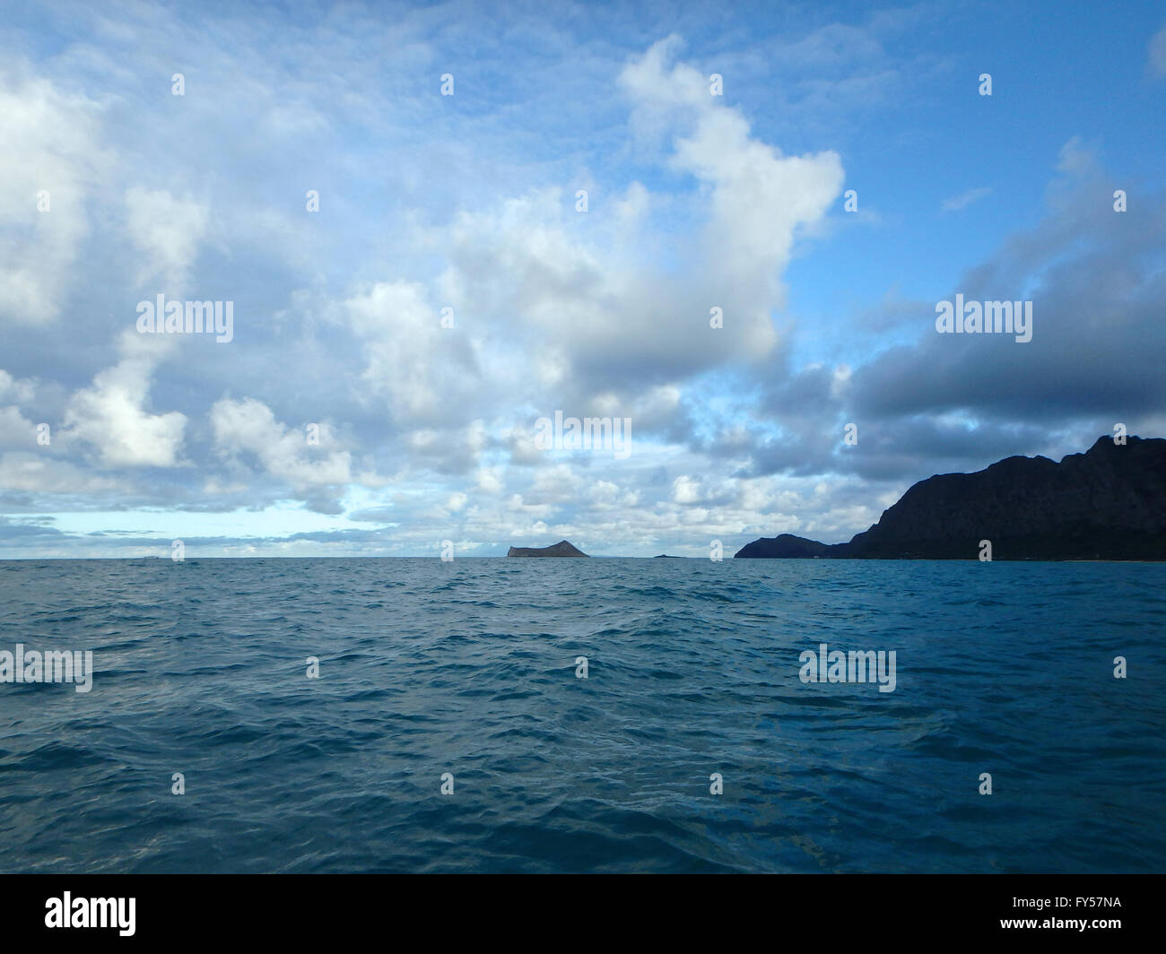 Gentle wave in Waimanalo Bay looking towards Rabbit island and Rock island at dusk on nice day Oahu, Hawaii.  September 2014. Stock Photo