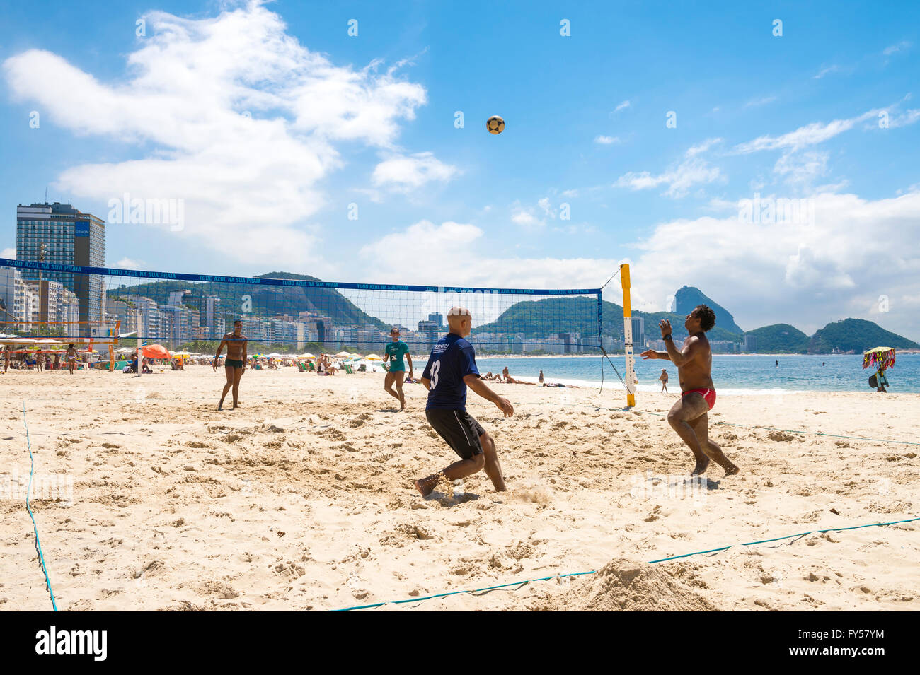 RIO DE JANEIRO - MARCH 15, 2016: Brazilian men play a game of futevolei (footvolley, a sport combining football and volleyball. Stock Photo