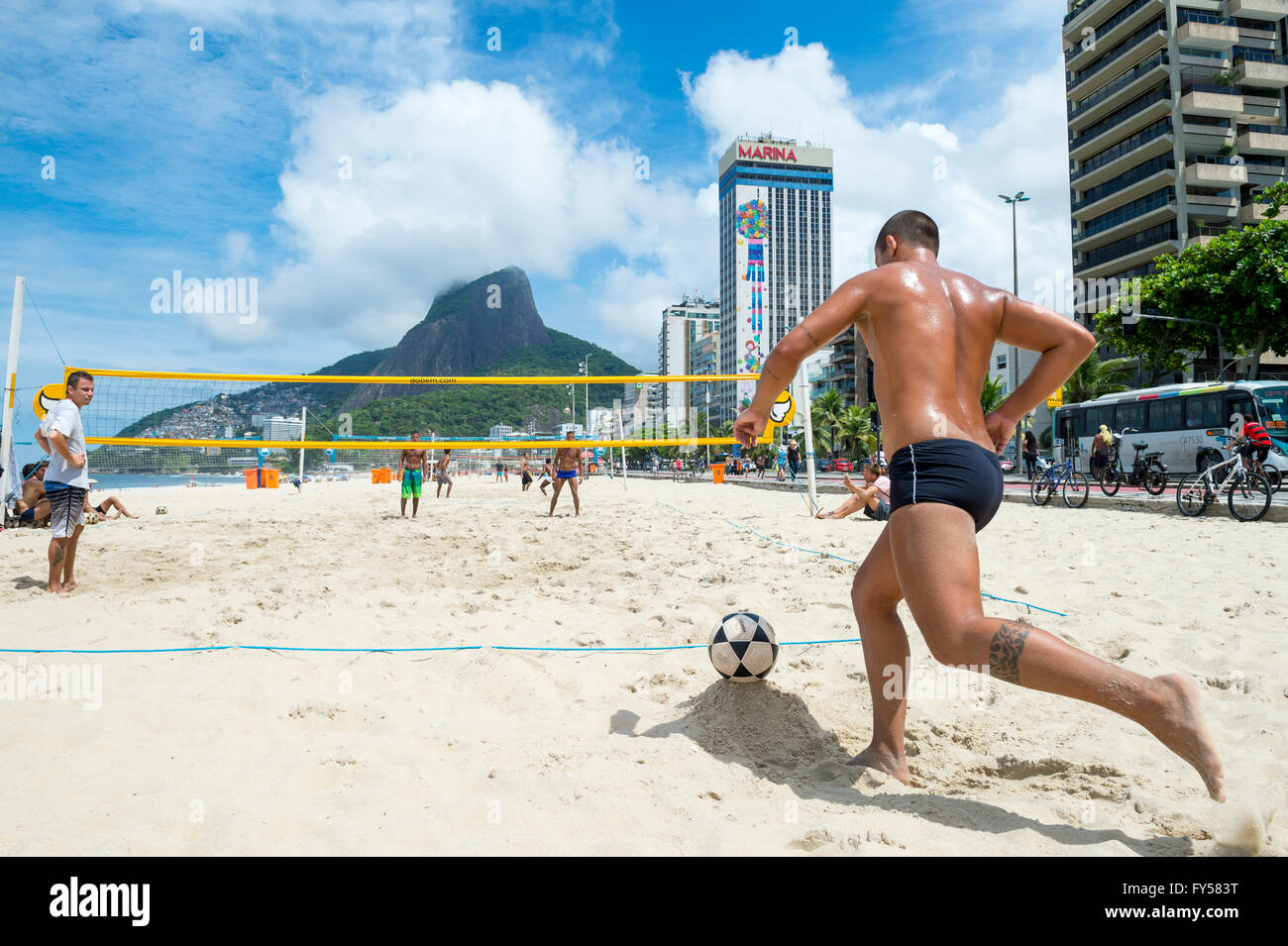 RIO DE JANEIRO - MARCH 17, 2016: Young Brazilian men play a game of futevolei (footvolley) on Ipanema Beach. Stock Photo