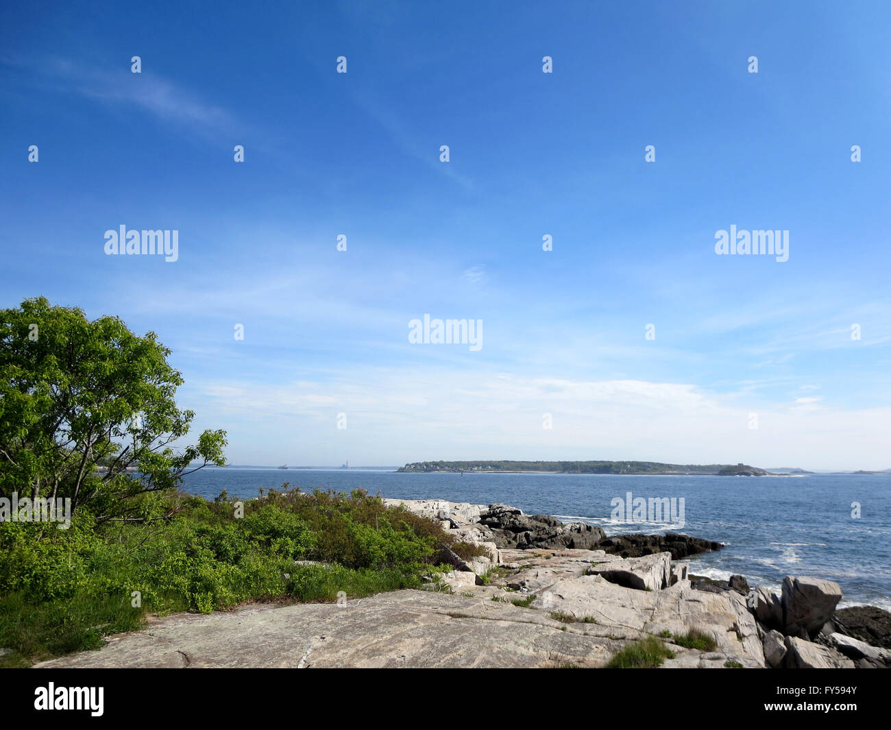 Peaks Island granite rocky Shoreline with trees and island in distance in Maine. Stock Photo