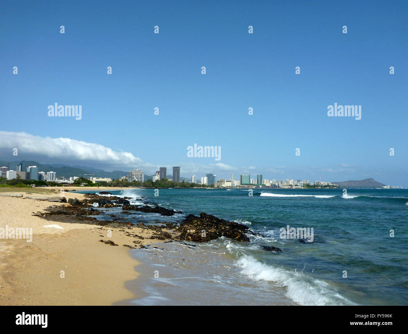 Sand Island beach off the coast of Oahu, Hawaii.  Featuring crashing waves and Downtown Honolulu, Waikiki in the background. Stock Photo