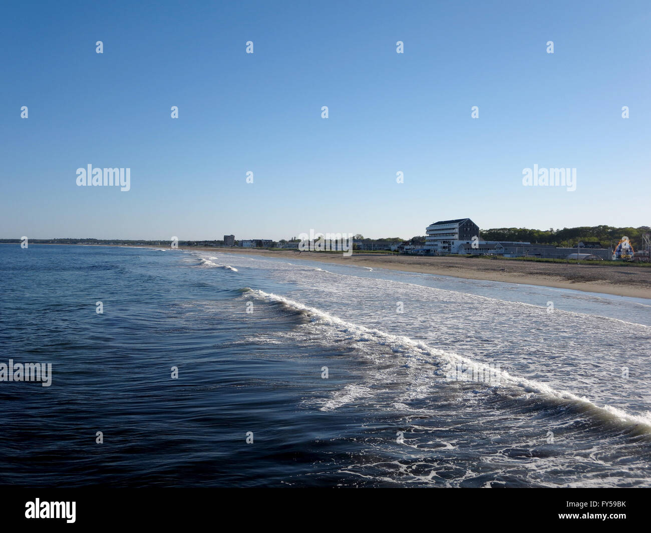 Waves lap on Old Orchard Beach with new hotel and amusement park on Maine Coastline south of Portland. Stock Photo
