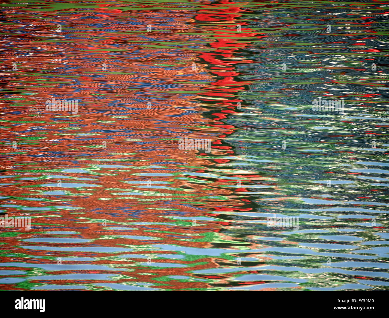 Red Blue Color pattern shimmers and reflects in ripples of water making a psychedelic pattern. Stock Photo