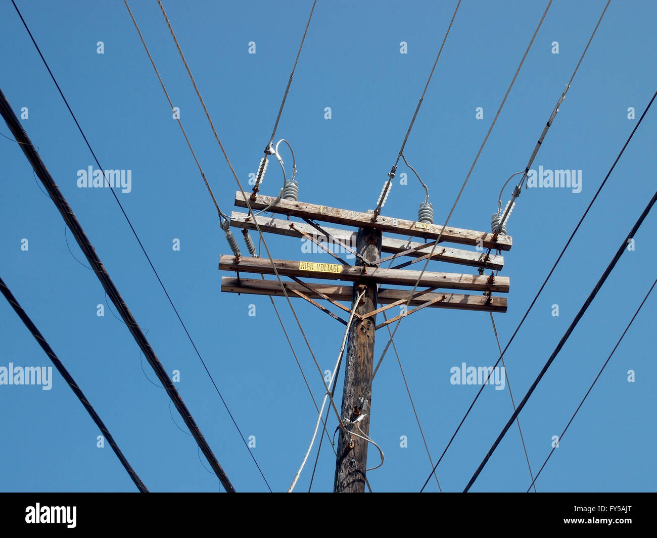 High Voltage Power Lines intersect at a wooden Utility pole on Oahu, Hawaii. Stock Photo