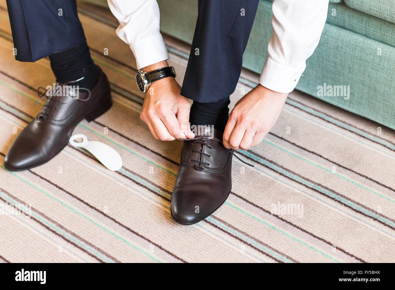 Close-up young man tying elegant shoes indoors Stock Photo