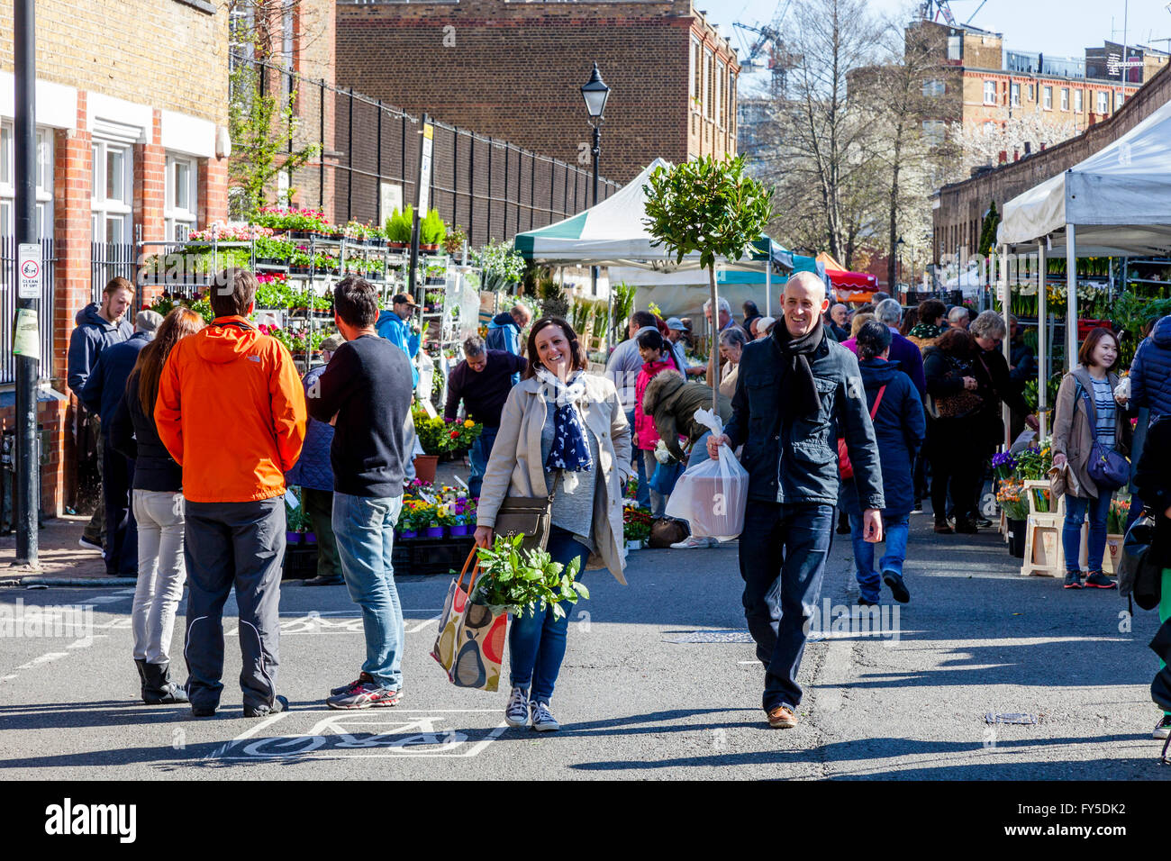 People Leaving Columbia Road Flower Market With Plants and Flowers