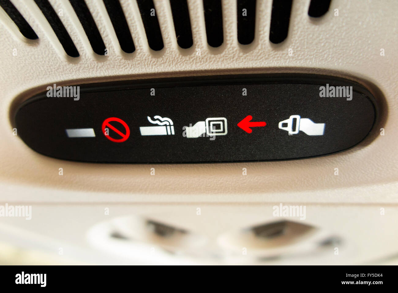 Aircraft 'Fasten seat belt / seatbelt' light sign lit up & illuminated