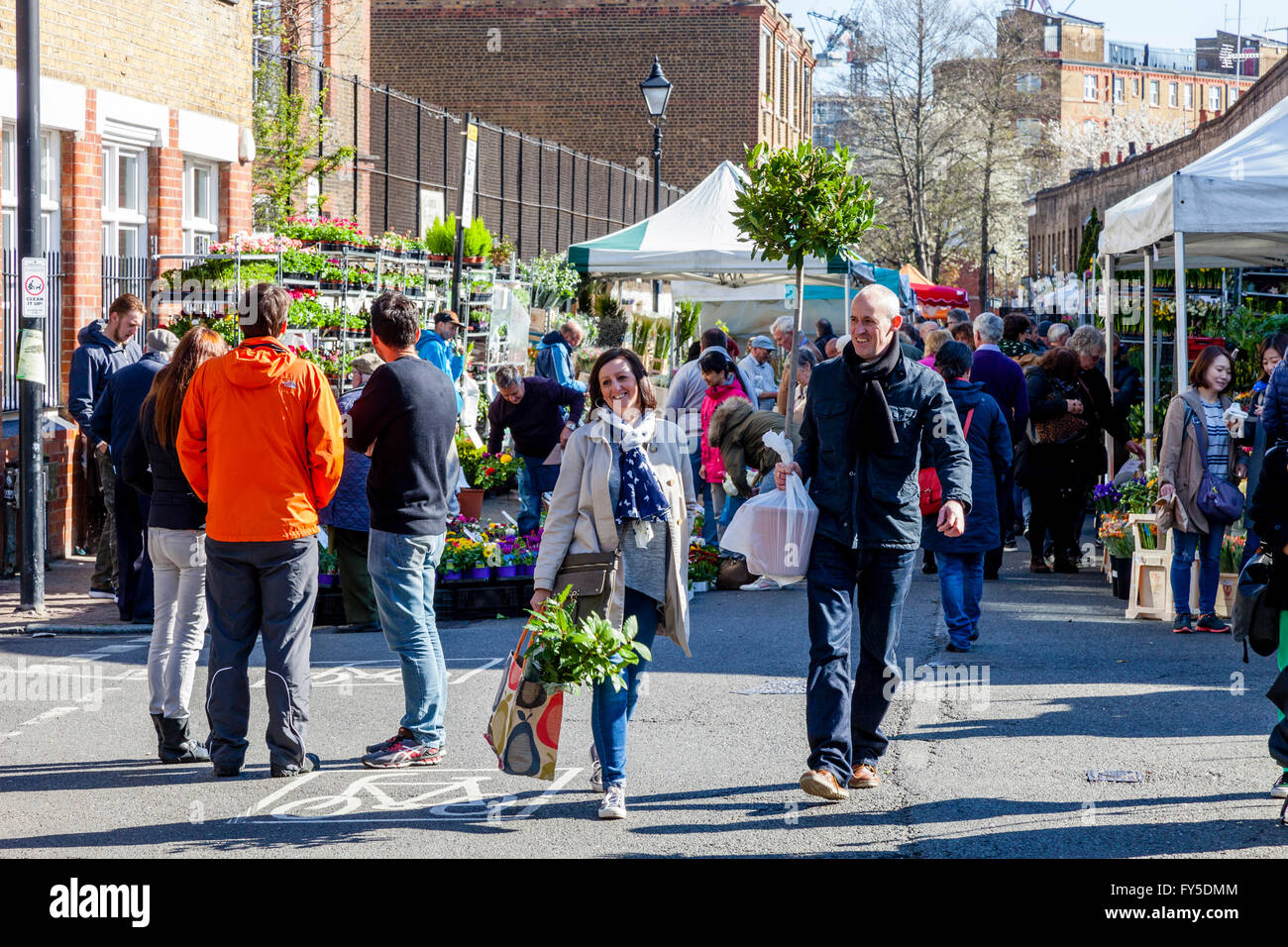 People Leaving Columbia Road Flower Market With Plants and Flowers