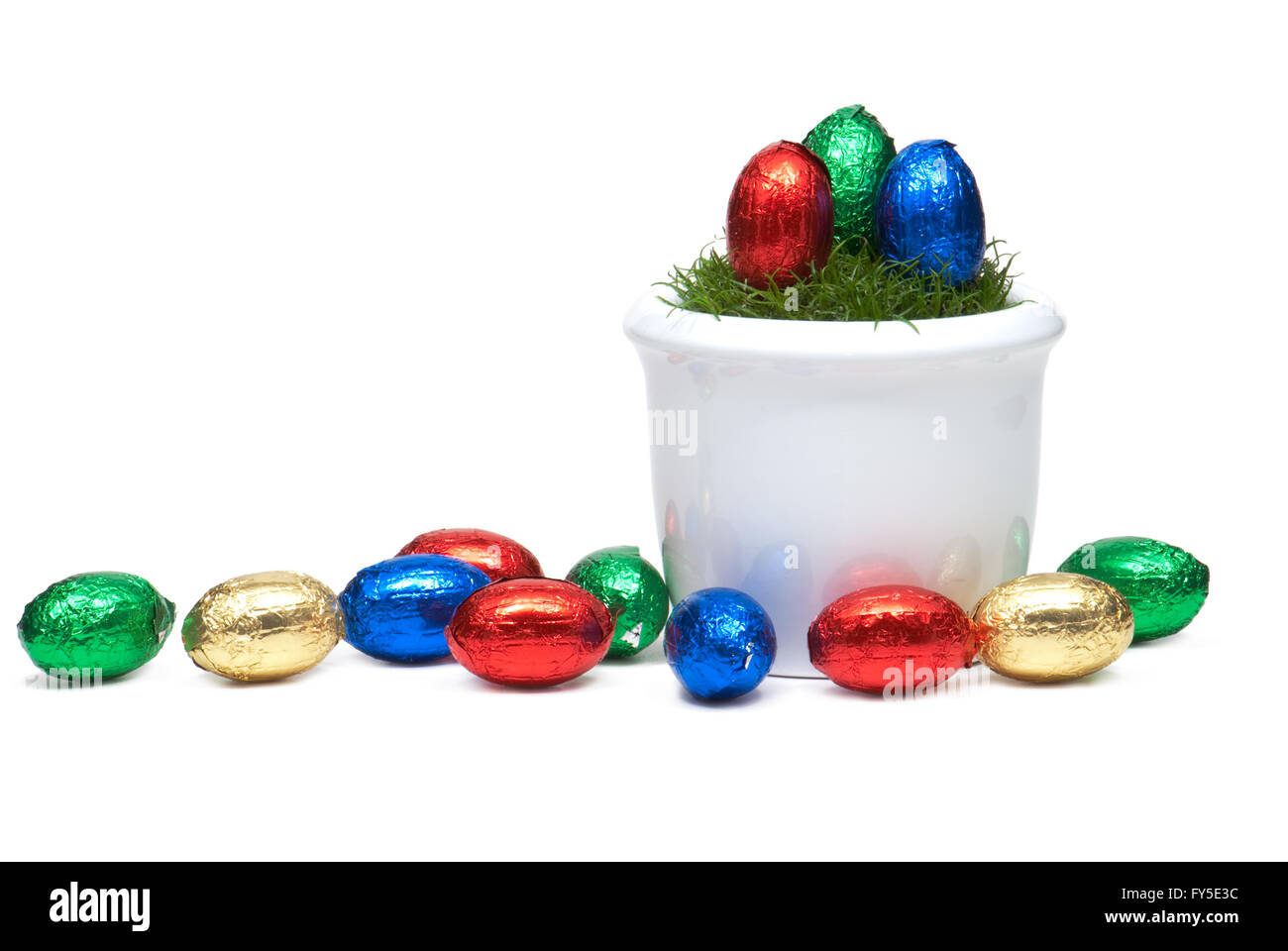 Flower pot with grass and Easter egss wrapped in colorful foil