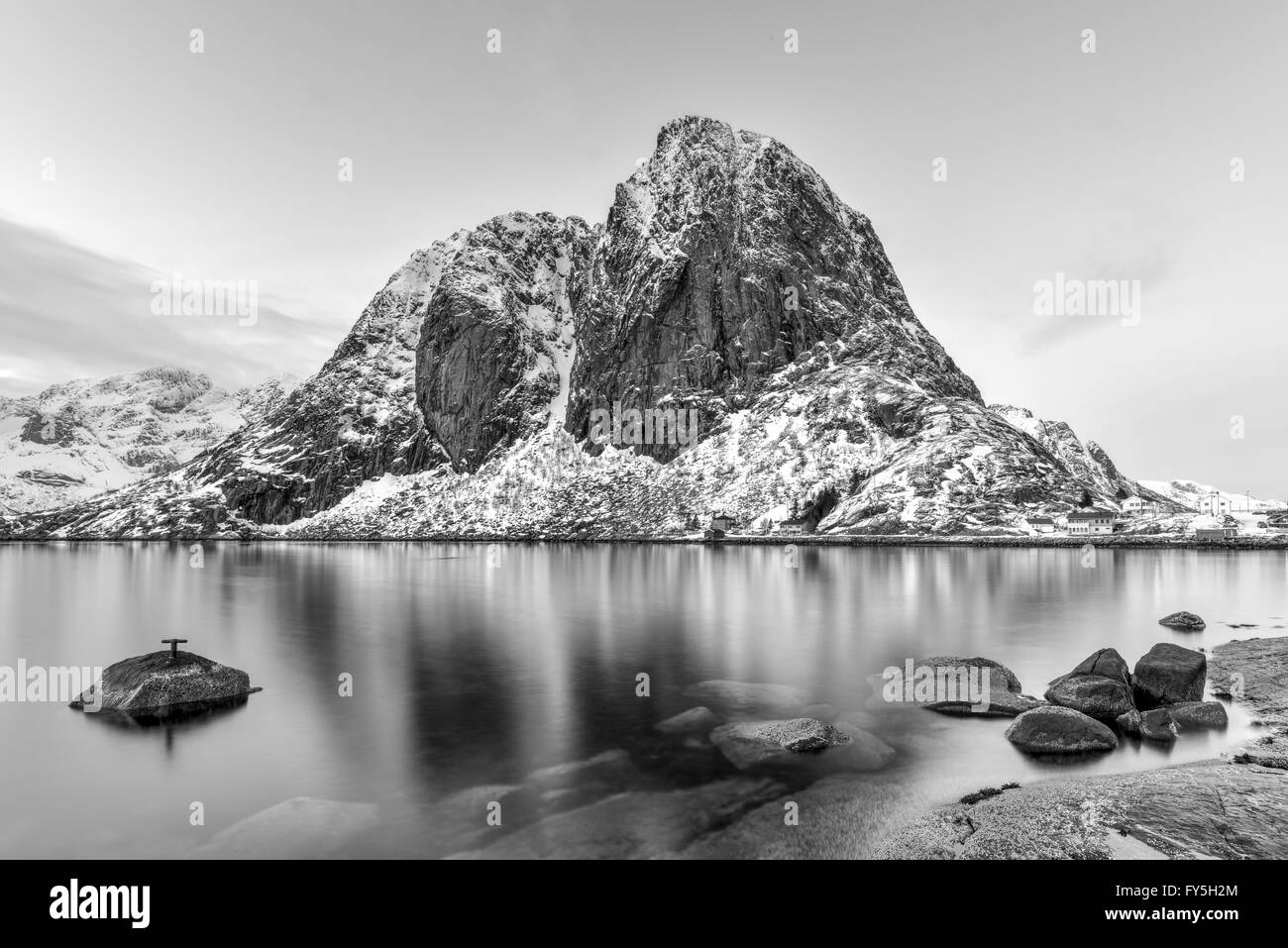 Fishing hut (rorbu) in the Hamnoy and Lilandstinden mountain peak in winter in Reine, Lofoten Islands, Norway. Stock Photo