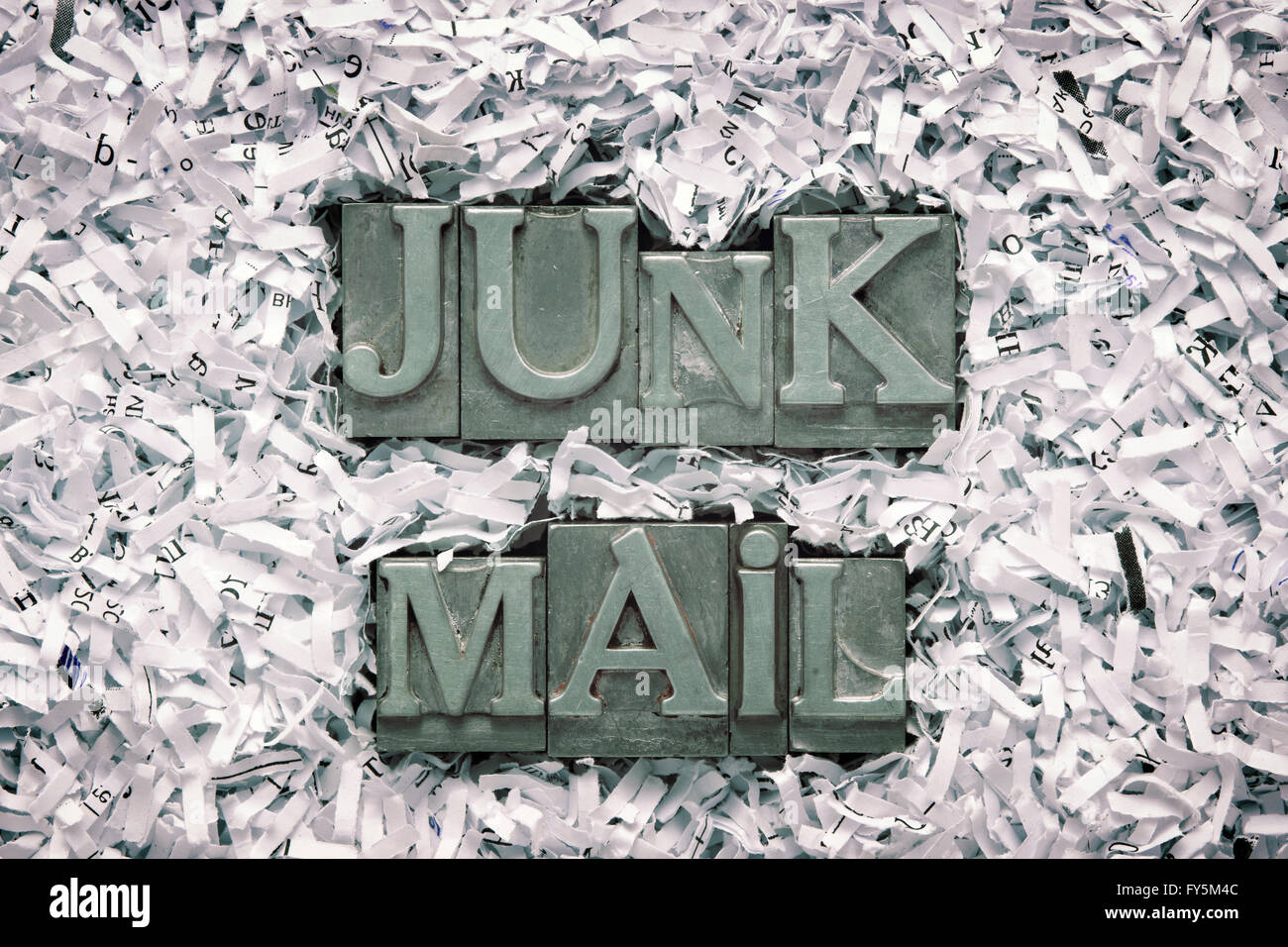 junk mail phrase made from metallic letterpress type inside of shredded paper heap Stock Photo