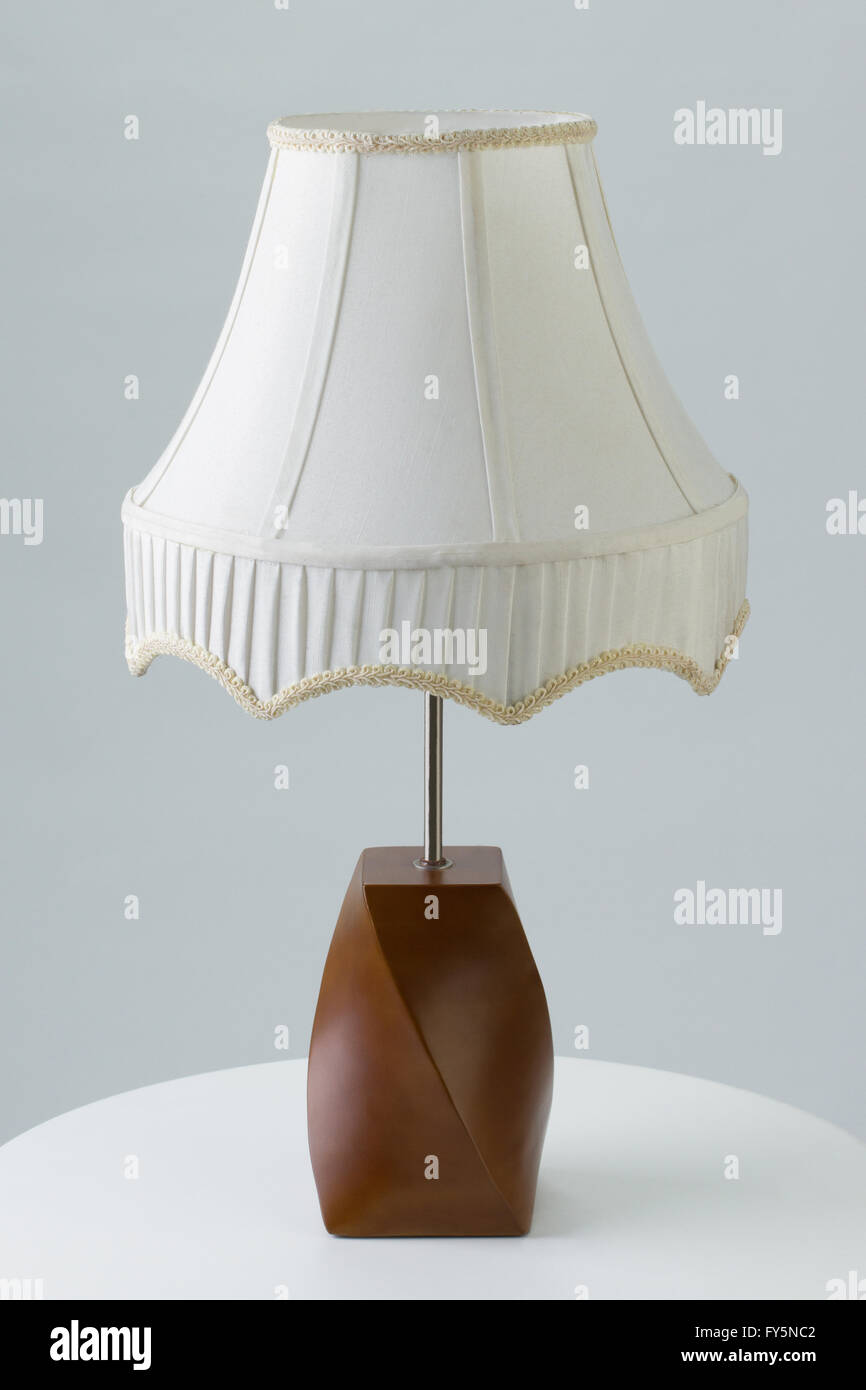 Table lamp on end table against gray background Stock Photo