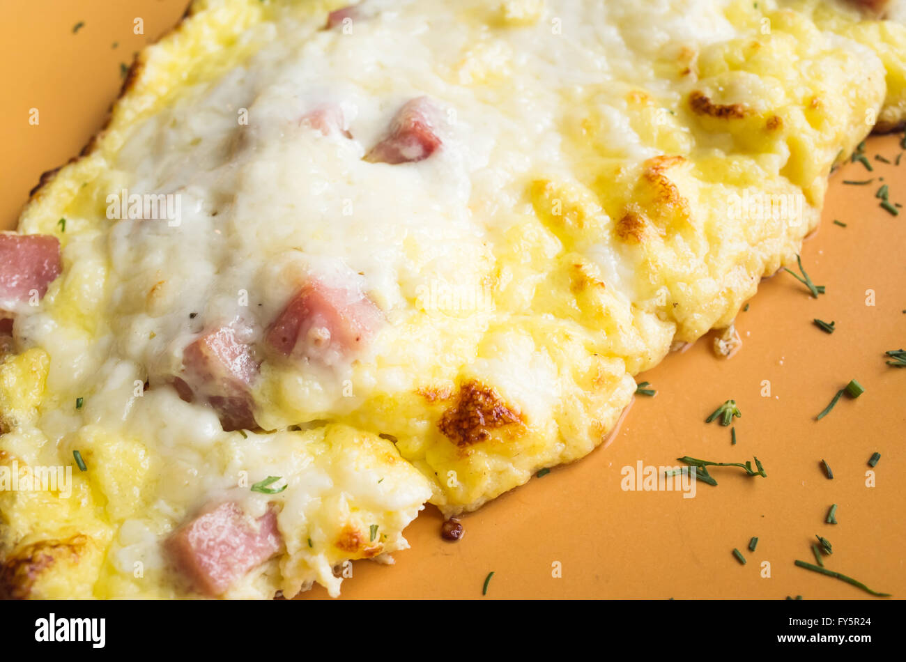 Freshly roasted omelet with ham and cheese on a plate. Breakfast theme Stock Photo