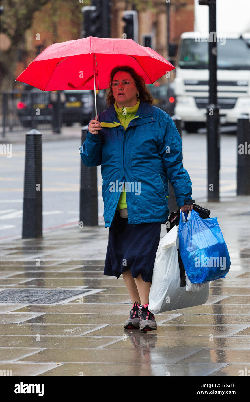 London, UK. 22nd April 2016. A woman walking with an umbrella in central London during rain and wet weather this afternoon. Credit: London pix/Alamy Live News Stock Photo