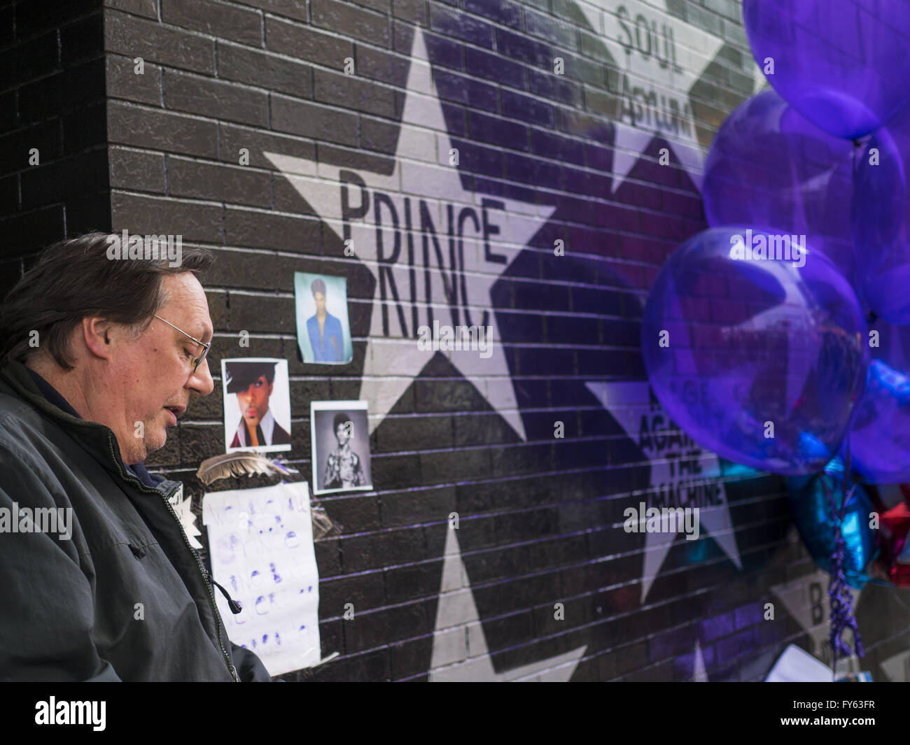 Minneapolis, MN, USA. 22nd Apr, 2016. A man pauses at a memorial to Prince in front of 1st Ave in Minneapolis. Thousands of people came to 1st Ave in Minneapolis Friday to mourn the death of Prince, whose full name is Prince Rogers Nelson. 1st Ave is the nightclub the musical icon made famous in his semi autobiographical movie ''Purple Rain.'' Prince, 57 years old, died Thursday, April 21, 2016, at Paisley Park, his home, office and recording complex in Chanhassen, MN. Credit:  Jack Kurtz/ZUMA Wire/Alamy Live News Stock Photo