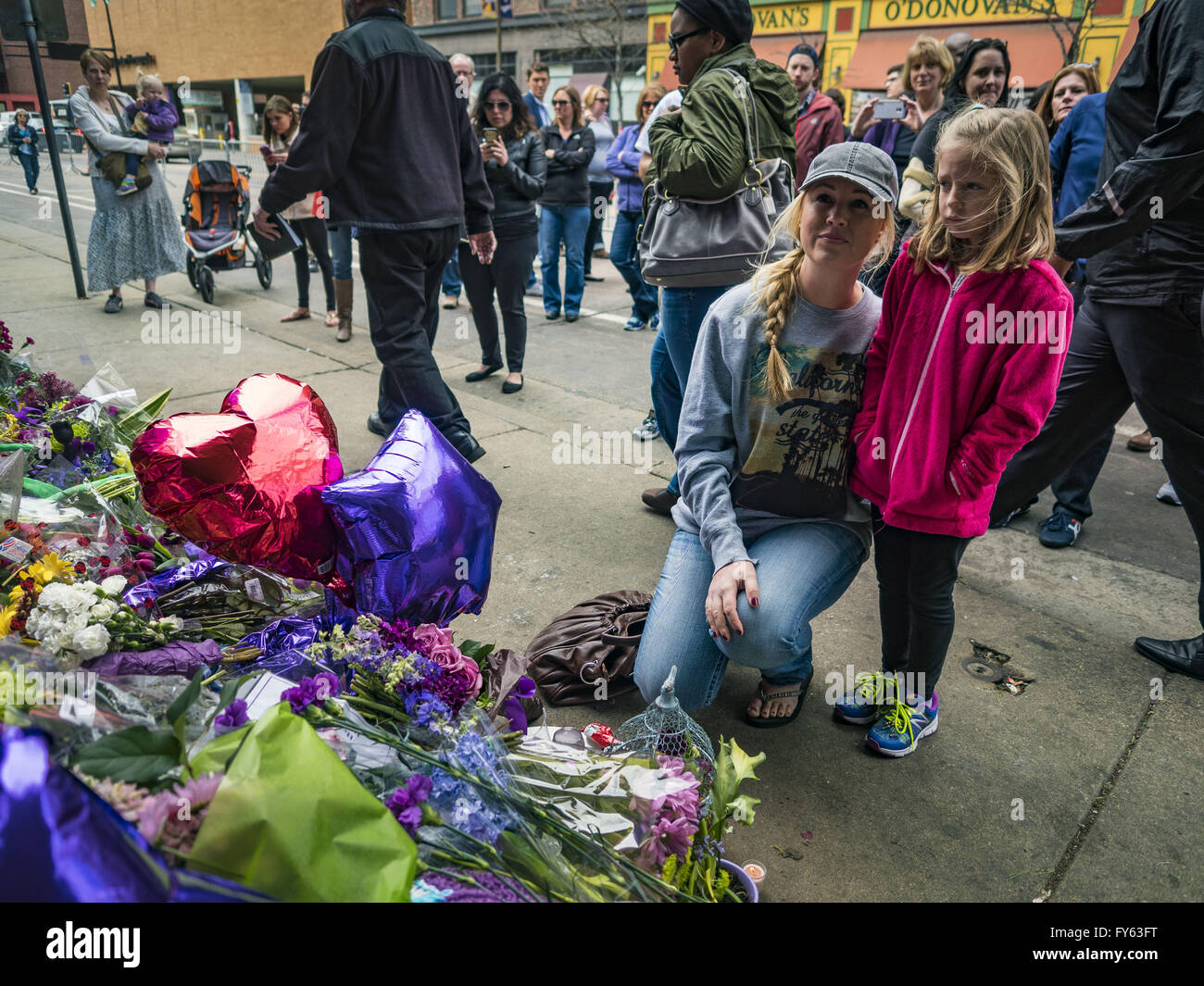Minneapolis, MN, USA. 22nd Apr, 2016. A woman and her daughter look at a memorial for Prince at 1st Ave in Minneapolis. Thousands of people came to 1st Ave in Minneapolis Friday to mourn the death of Prince, whose full name is Prince Rogers Nelson. 1st Ave is the nightclub the musical icon made famous in his semi autobiographical movie ''Purple Rain.'' Prince, 57 years old, died Thursday, April 21, 2016, at Paisley Park, his home, office and recording complex in Chanhassen, MN. Credit:  Jack Kurtz/ZUMA Wire/Alamy Live News Stock Photo