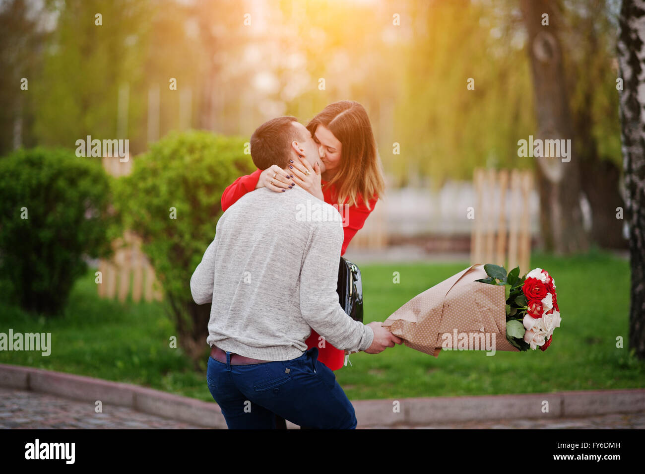 Marriage proposal. Kissed girl and boyfriend with bouquet of ...