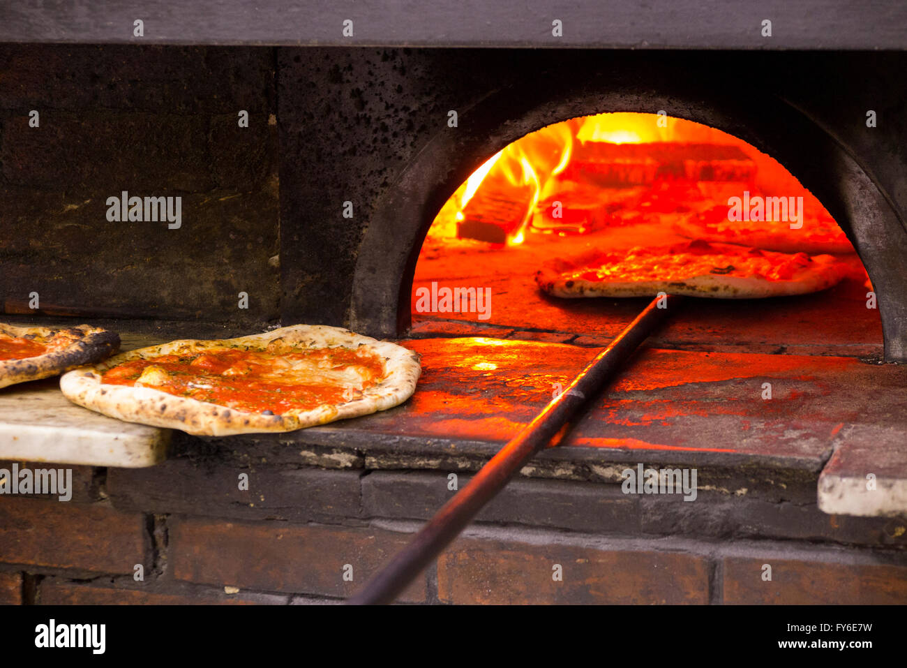 Looking inside a wood burning pizza oven at pizzas being baked in famous Italian restaurant in