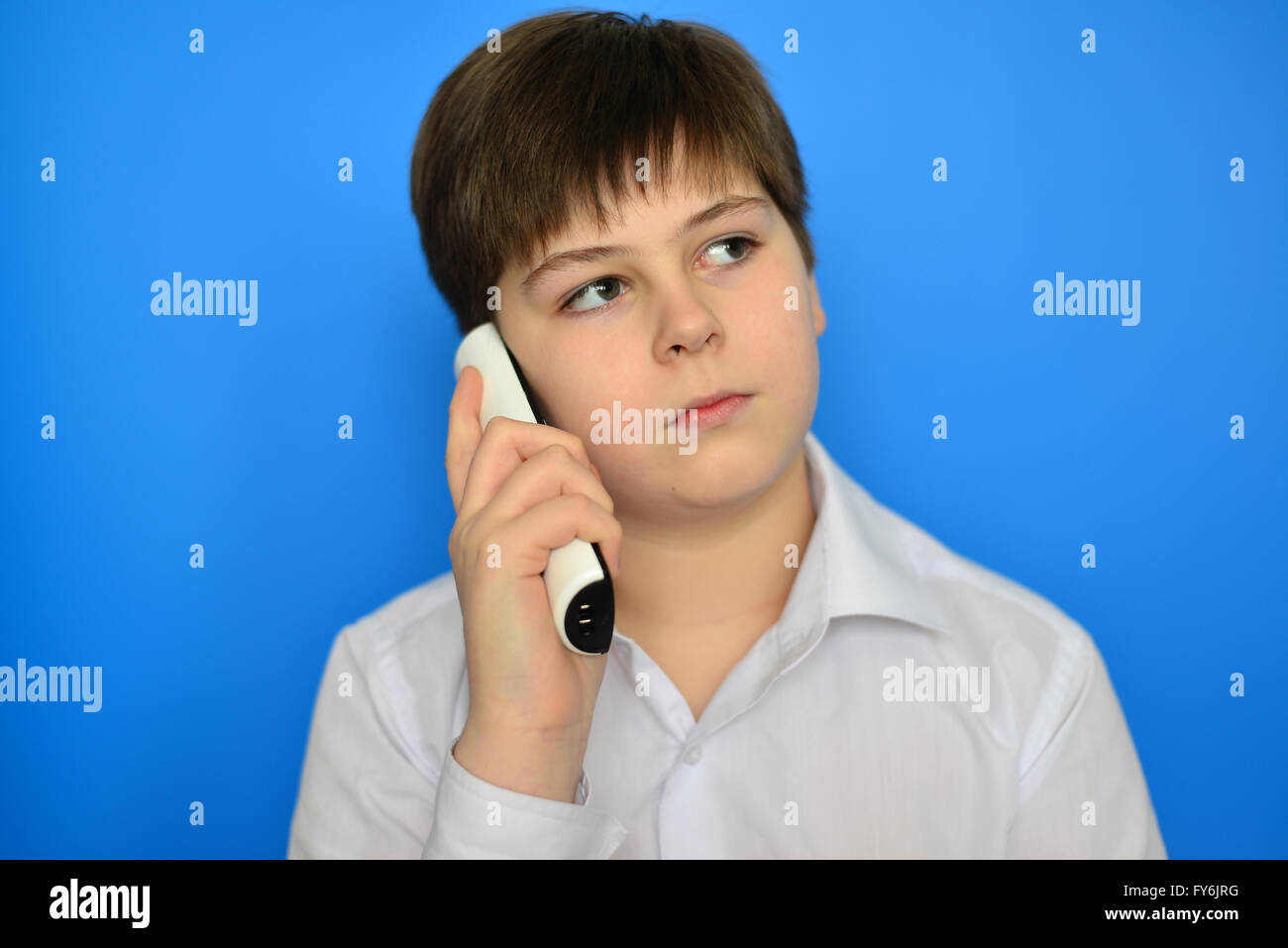 Teen boy talking by radiotelephony on a blue background Stock Photo