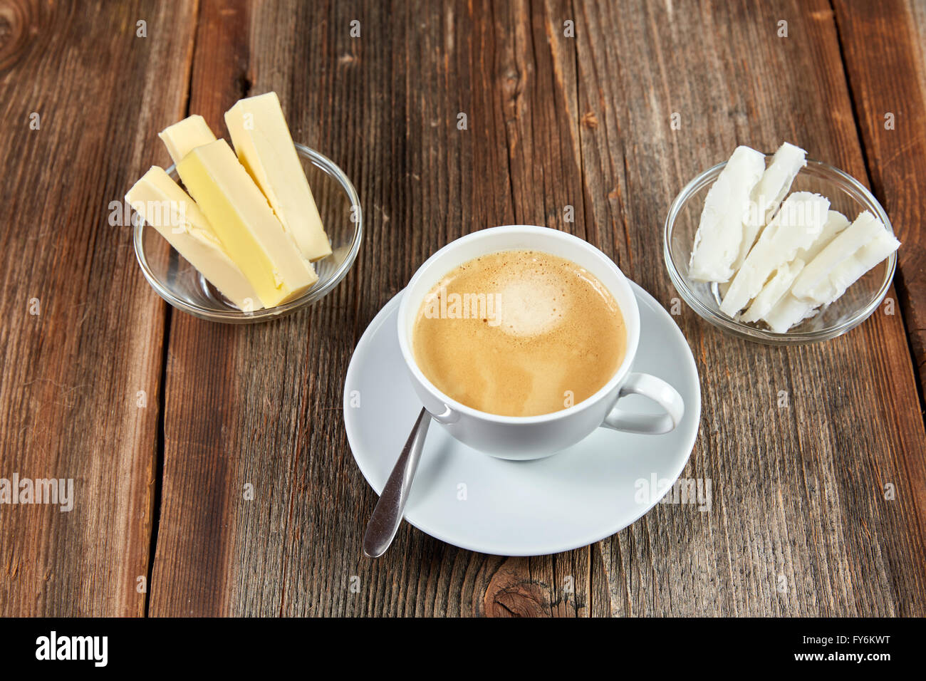 Bulletproof coffee in white cup with butter and coconut oil on a wooden table Stock Photo