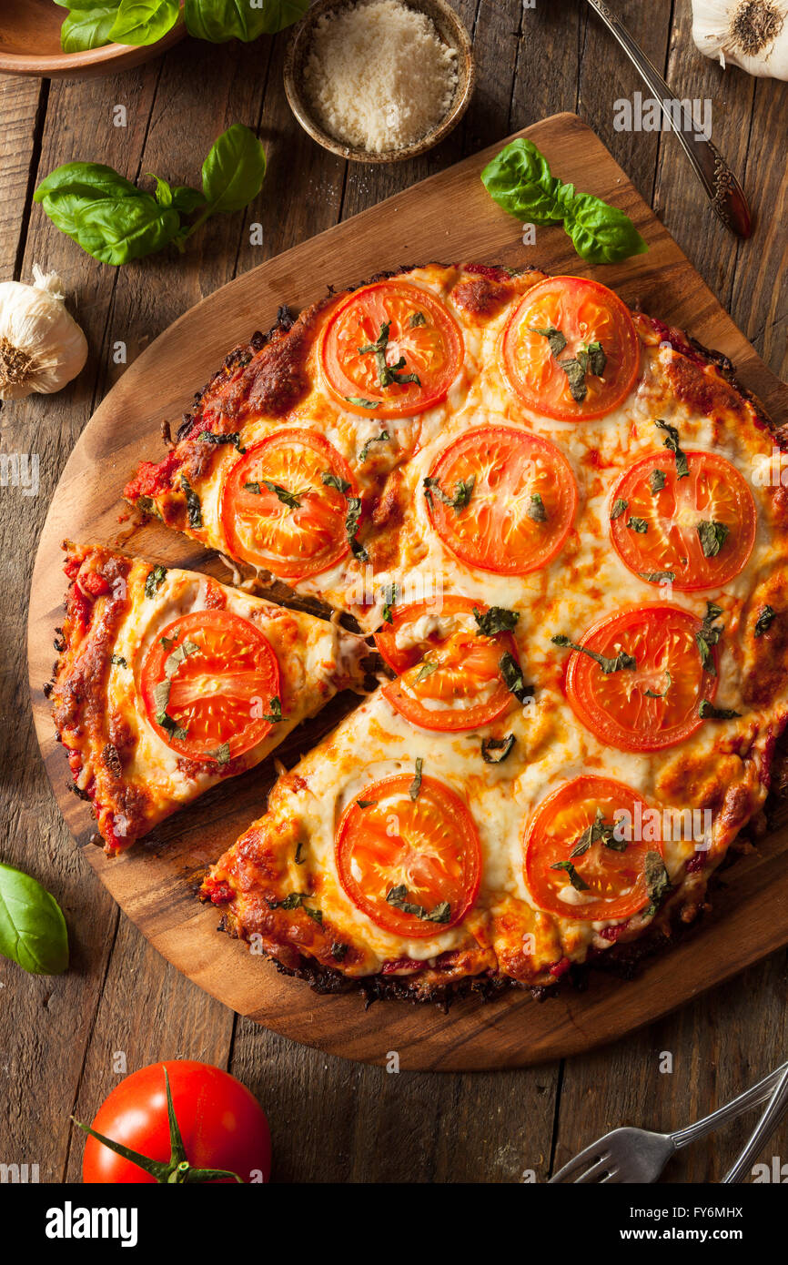 Homemade Vegan Cauliflower Crust Pizza with Tomato and Basil Stock Photo