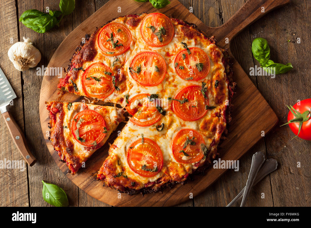 Homemade Vegan Cauliflower Crust Pizza with Tomato and Basil Stock Photo