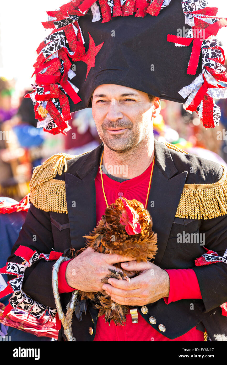 A Cajun Mardi Gras Capitaine holds a live chicken before throwing it ...