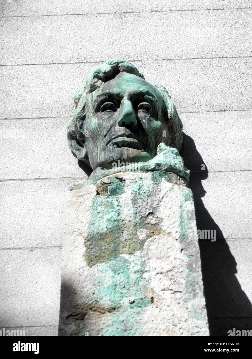 Face Statue of President Abe Lincoln sitting on a pedestal on the campus of UC Berkeley. With Green dripping lines forming from Stock Photo