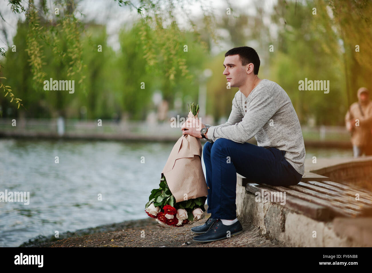 Man with a bouquet of flowers waiting for his girlfriend ...