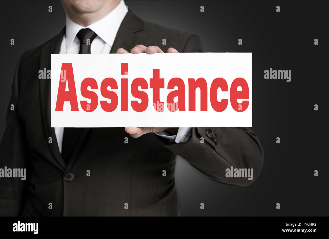 Assistance placard is held by businessman. Stock Photo