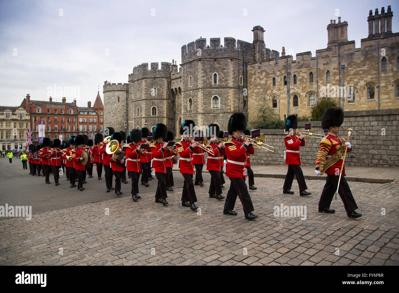The Band of the Irish Guards lead the 1st Battalion of the Coldstream Guards past the Henry VIII gates of Windsor Castle Stock Photo